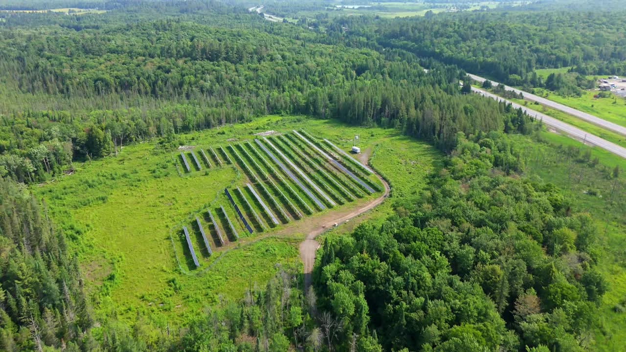 Solar Farm With Renewable Energy Generating Panels Surrounded By A Lush Forest Landscape. Aerial Shot.