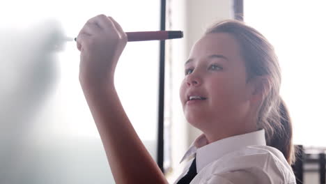 estudiante de secundaria vestida con uniforme usando una pizarra interactiva durante la lección