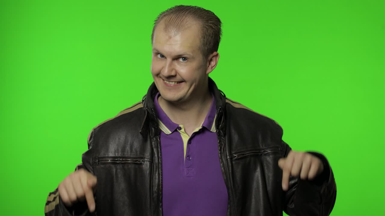 hombre rocker pidiendo suscribirse, tratando de controlar, señalando con los dedos hacia abajo.