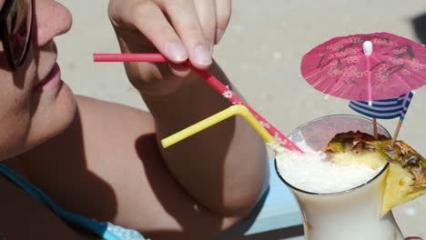 woman enjoying summer day with cocktail on beach