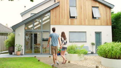 couple walking towards modern home