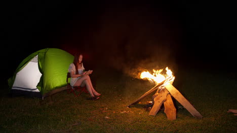 Niña-Asiática-Acampando-Por-La-Noche-Manténgase-Conectada-A-Internet-Usando-Una-Tableta-En-Un-área-Remota-Viajando-Al-Aire-Libre