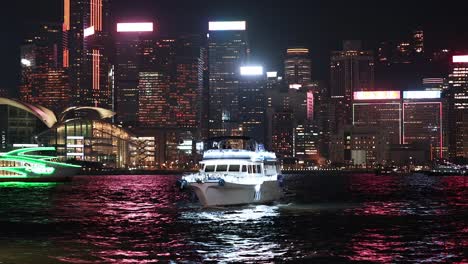 a boat moves towards the illuminated cityscape