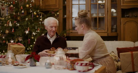 Junge-Frau,-Die-Dem-Großvater-Zu-Hause-Ein-Weihnachtsgeschenk-Gibt