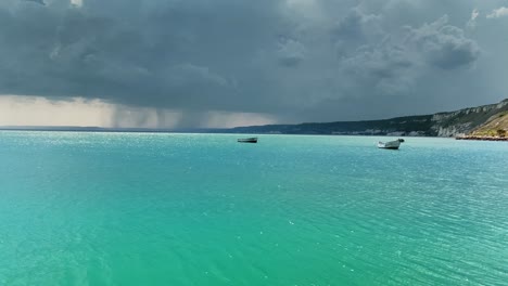 perfect-clear-blue-cyan-water-and-dramatic-sky-with-raiN-clouds-at-the-background
