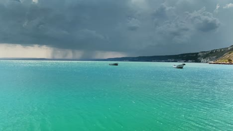 agua cian azul clara perfecta y cielo dramático con nubes de lluvia en el fondo