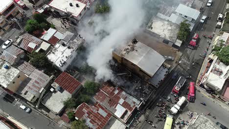 Aerial-view-of-a-building-fire,-a-massive-smoke-cloud-rising-from-the-flaming-structure,-in-Brazil---pull-back-drone-shot