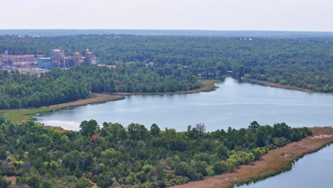 Moving-slowly-to-the-left-and-down-above-a-small-peninsula-and-a-large-lake-inlet-that-has-a-power-plant-behind-it