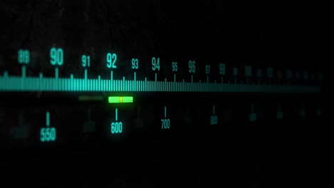 A-static-sequence-of-a-radio-tuner-display-with-glowing,-light-blue-text-and-bars-on-a-black-background