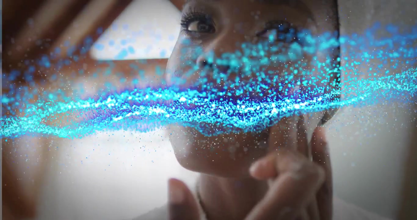Giovane donna di colore che applica crema viso con sovrapposizione di particelle digitali.