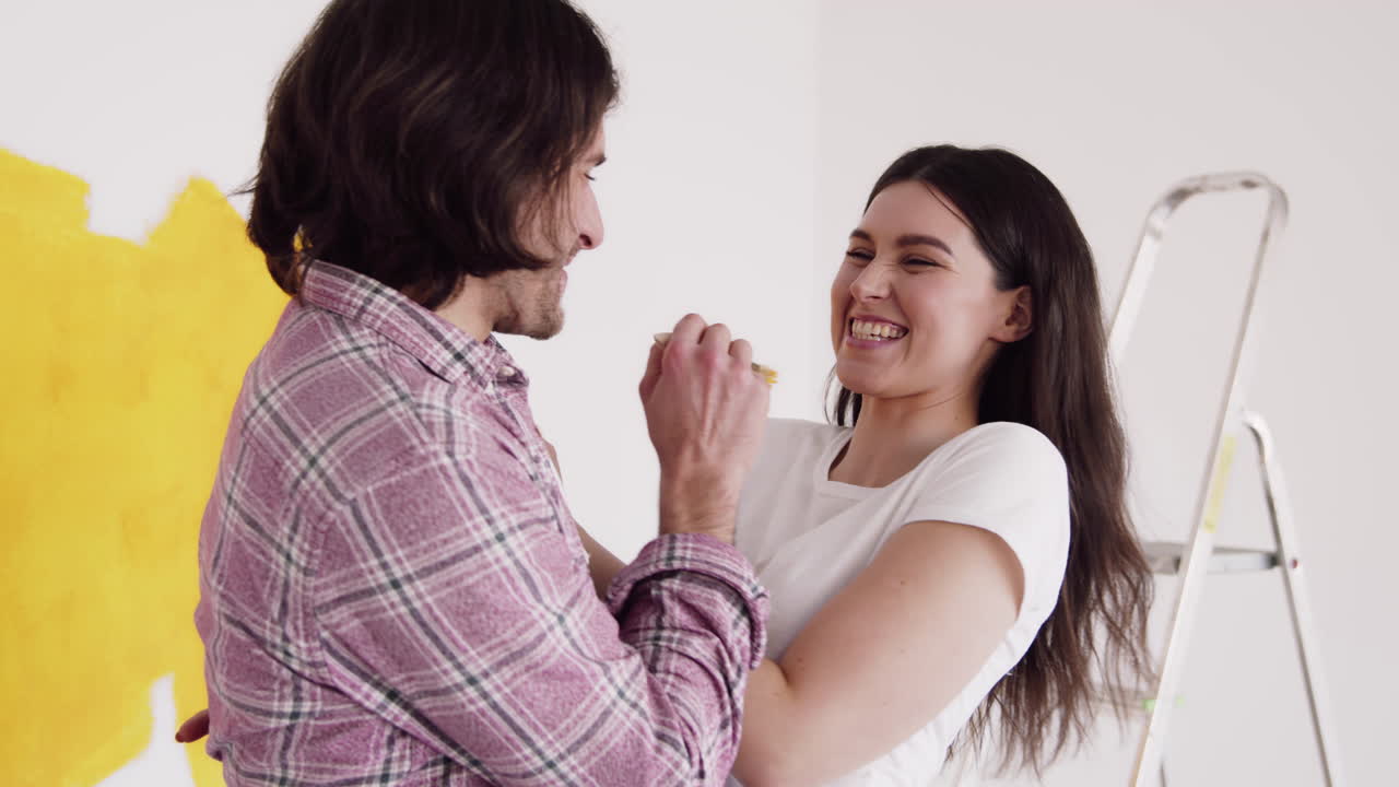 pareja pintando una pared juntos