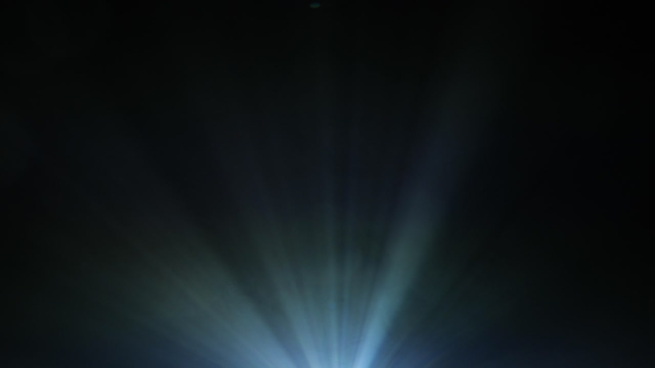 haz de proyector de video que brilla a través del humo con movimientos de foque