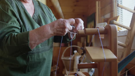 senior woman placing woollen thread on weaving machine 4k