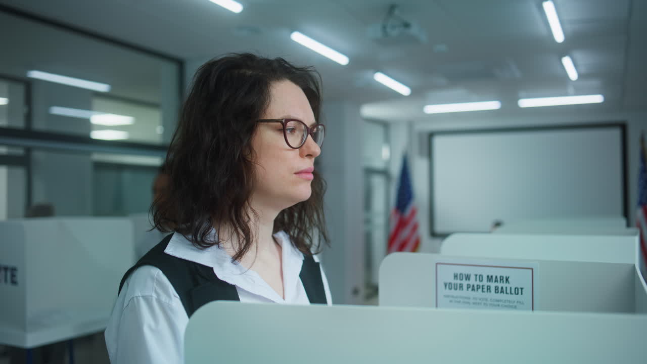 Close up Shot of American Female Voter Thinking in Voting Booth at Polling Station Close up Shot of American Female Voter Thinking and Choosing which Presidential Candidate to Vote for in Voting Booth at Polling Station us Citizen during National Election Day in the United States