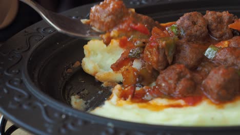 close-up of a plate of meatballs with mashed potatoes and sauce