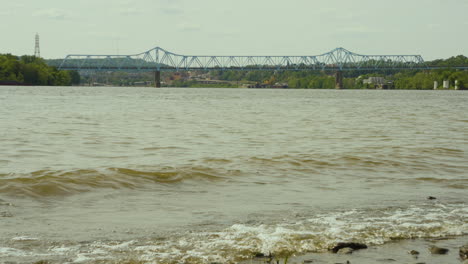 An-Einem-Bewölkten-Tag-Schlagen-Wellen-Am-Ufer-Des-Ohio-River-Mit-Der-Rochester-Monaca-Brücke-Im-Hintergrund