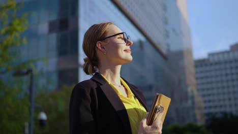 grateful happy inspired businesswoman in glasses looking far