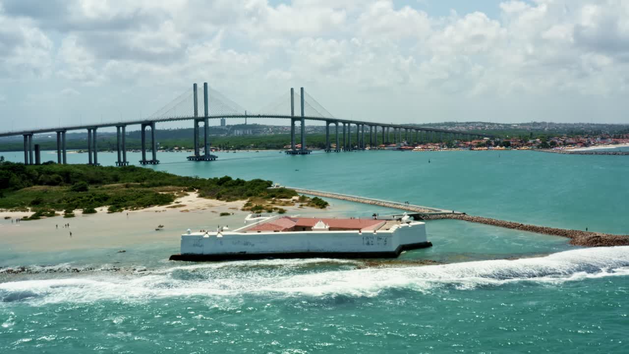 브라질 리오 그란데 도 노르 테 해변 수도 나탈 뒤에 큰 뉴턴 나바로 다리가있는 암초에 지어진 역사적인 별 모양의 레이 마고스 요새의 회전 공중 드론 샷