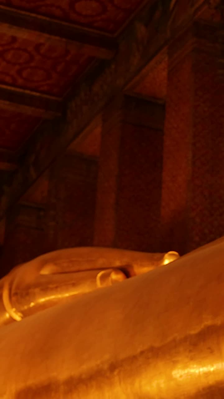 Statua dorata del Buddha reclinato in un tempio di Bangkok