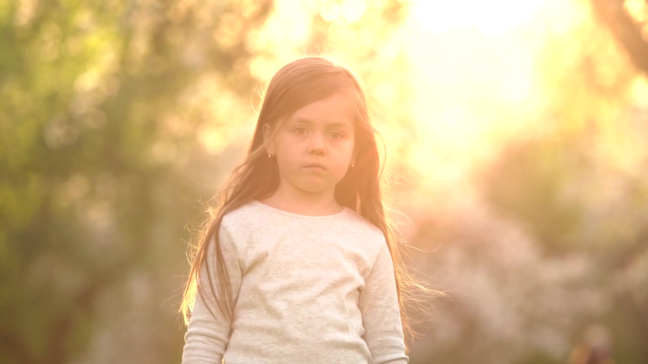 Menina jovem brincando em um parque ao pôr do sol