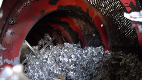 cinematic shot of recycled metal foil being shredded in a recycling plant with a ball mill