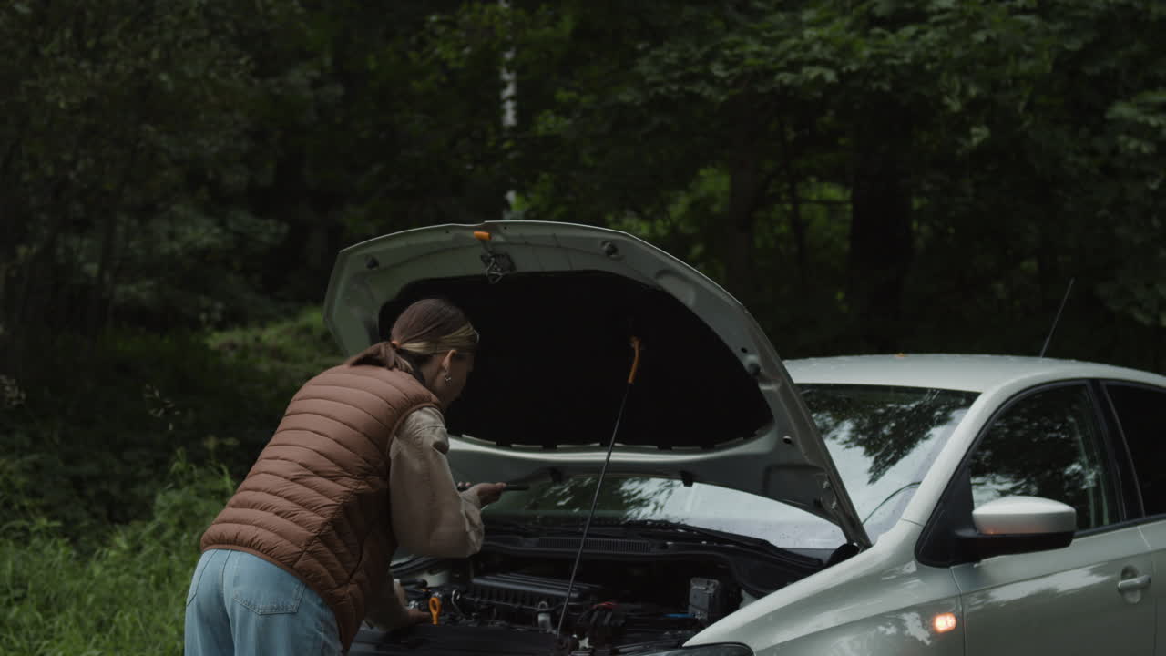 Woman Inspecting Car Engine on Roadside
