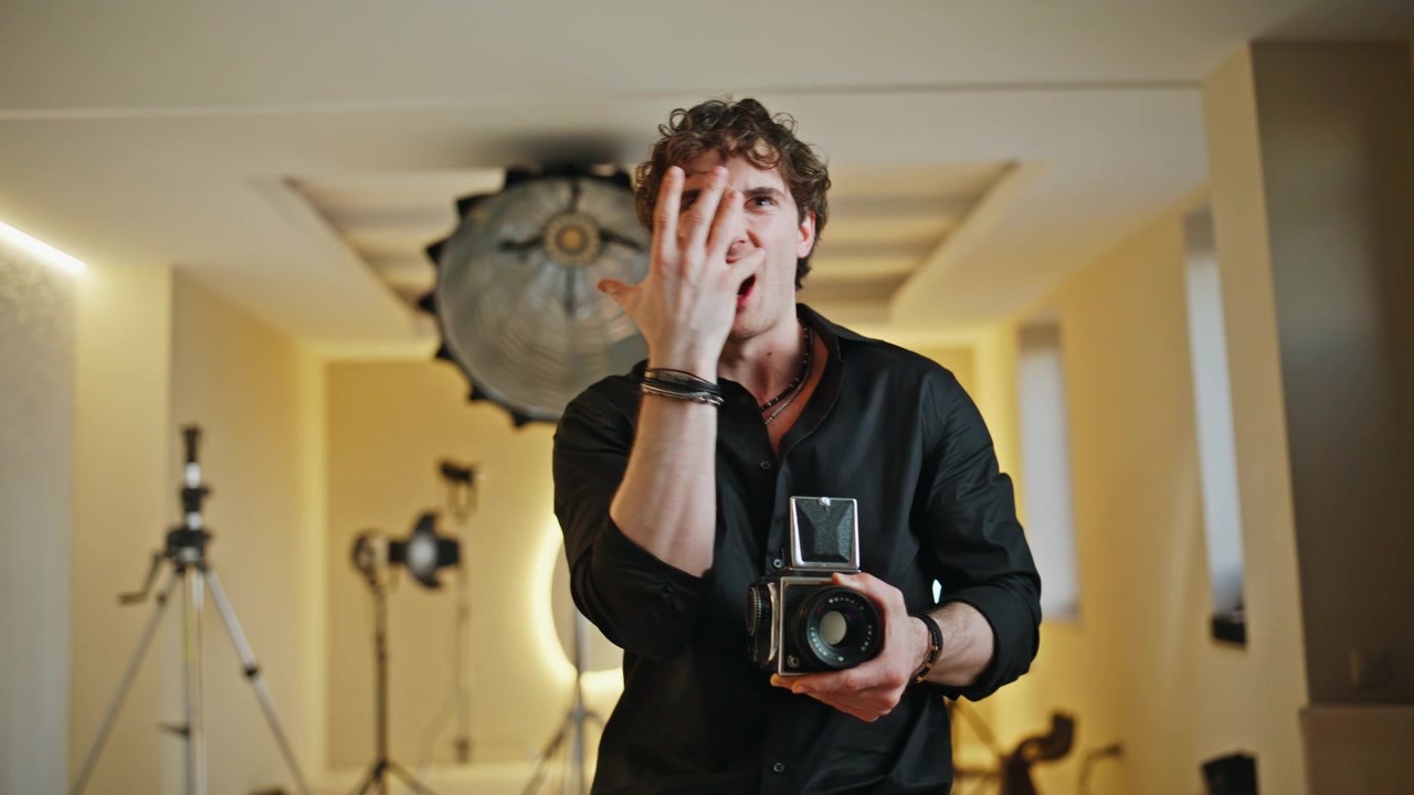 Man holding vintage medium format camera studio. Creative photographer