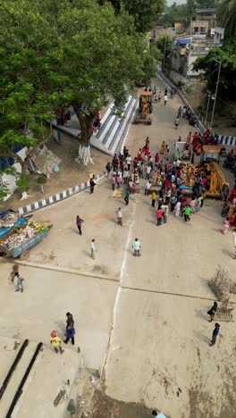 drone shot of people gathering idols of goddess durga for immersion in ganga river, water pollution