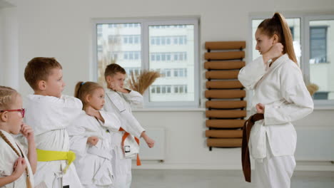 niños en kimono blanco en la clase de artes marciales