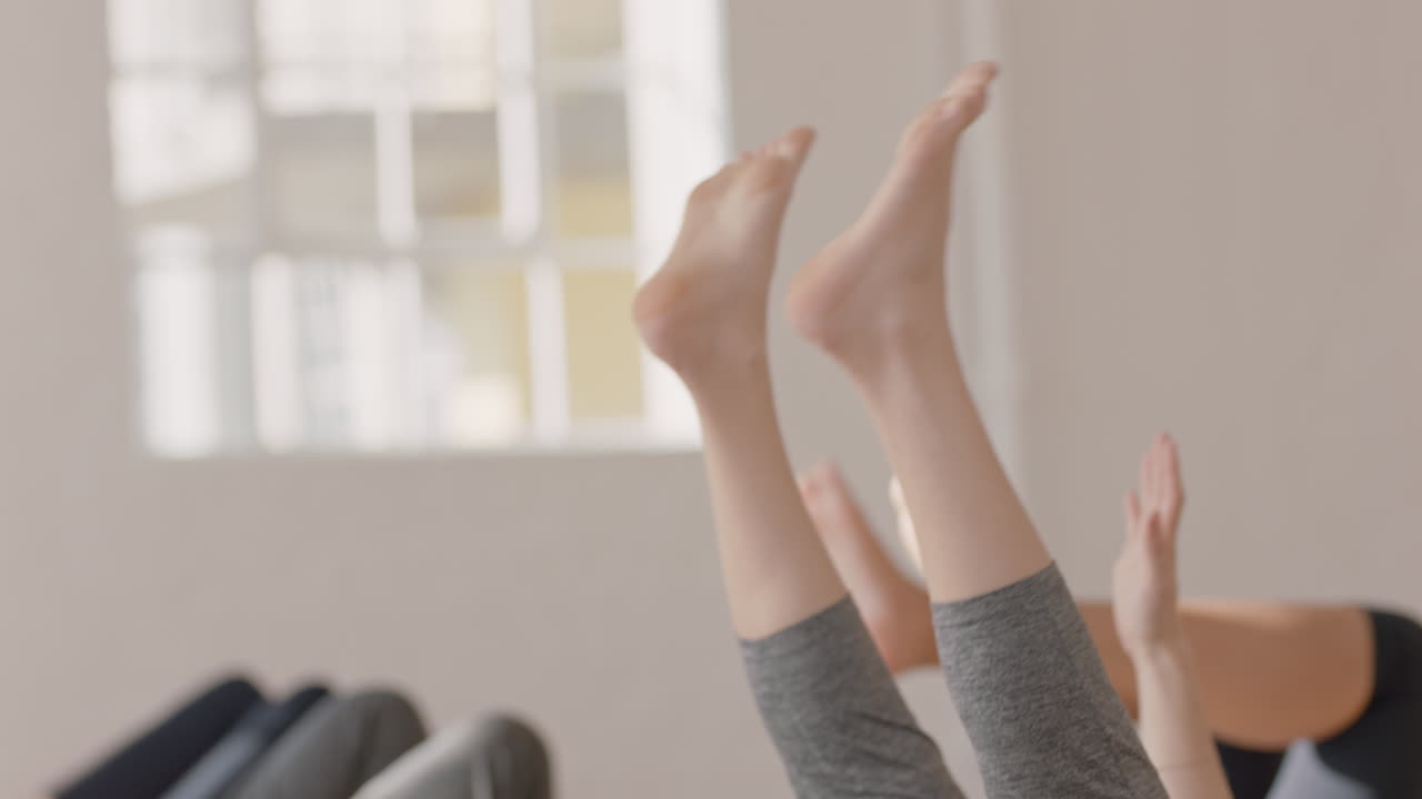 스튜디오에서 그룹 체력 운동을 즐기며 운동 매트에 누워 스트레칭을 연습하는 건강한 임산부의 요가 수업