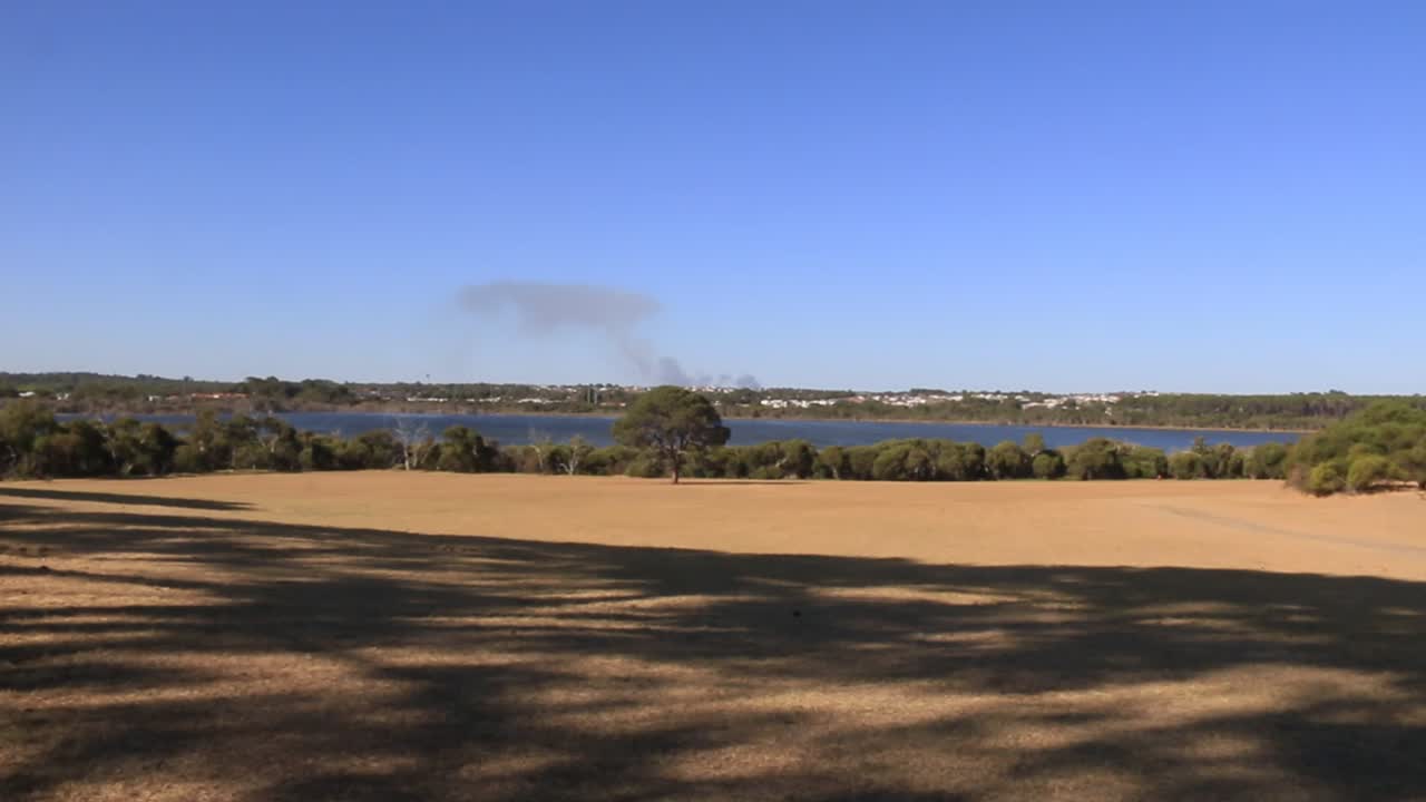 el agua azul del lago jonndalup perth visto desde debajo de la sombra del árbol
