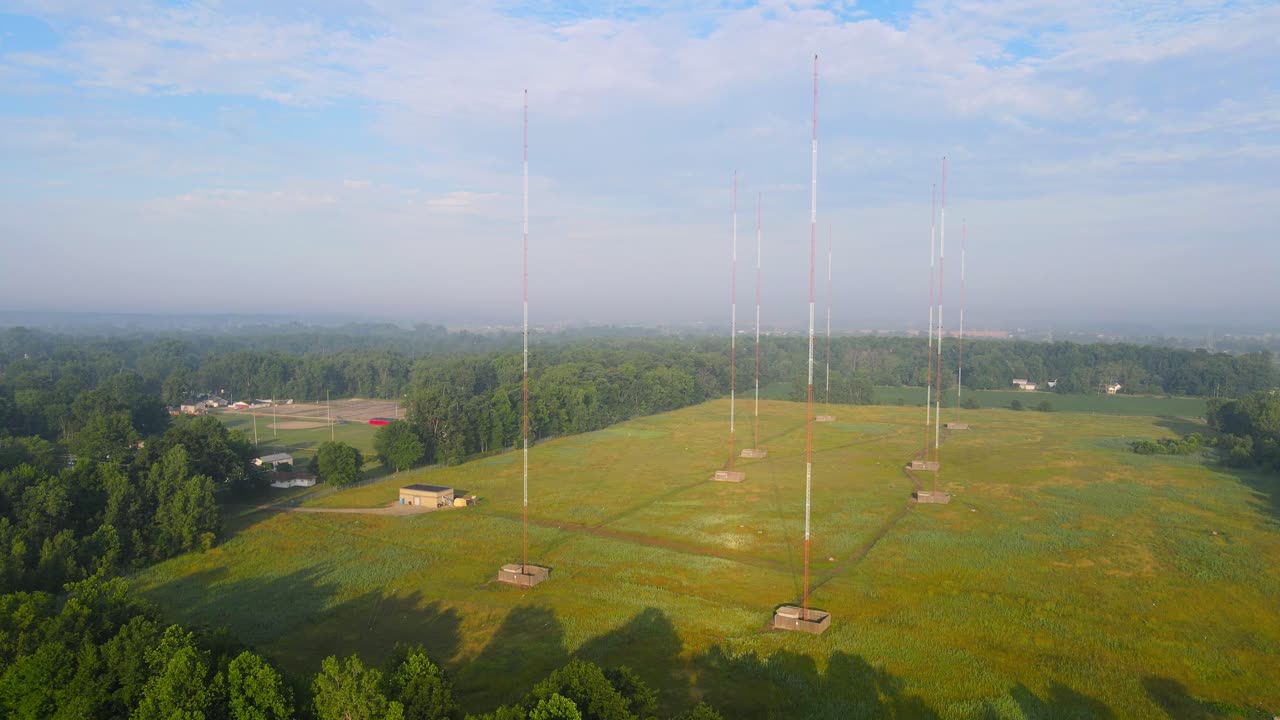 Array of tall communication towers in open green field in midwest, Michigan, USA