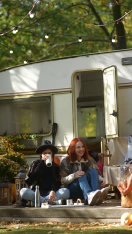 friends enjoying a relaxing autumn afternoon by a campervan