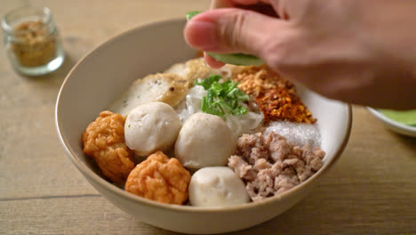 pequeños fideos de arroz planos picantes con bolas de pescado y bolas de camarones sin sopa - estilo de comida asiática