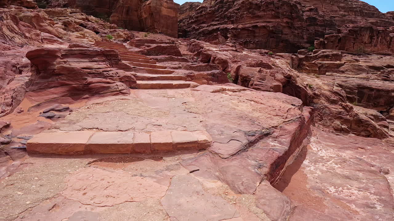 Walking up by the stairs of the ancient city ruins. Tour by the stunning canyons of Petra, Jordan, West Asia.