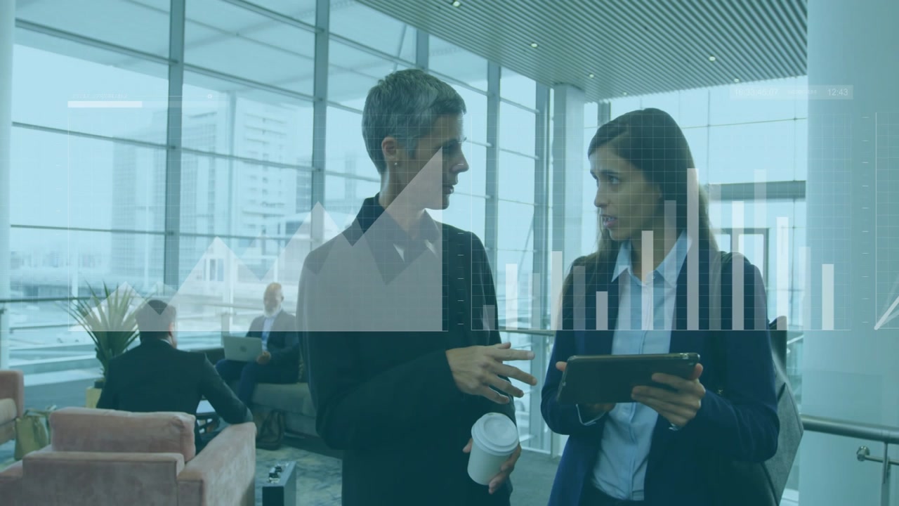 Man pointing while woman using tablet at terminal animating charts over tablet for finance decision