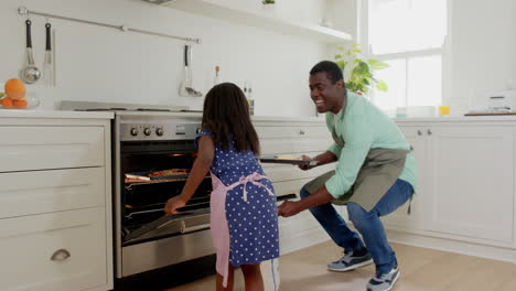 african american, father and daughter baking together in kitchen, enjoying quality family time
