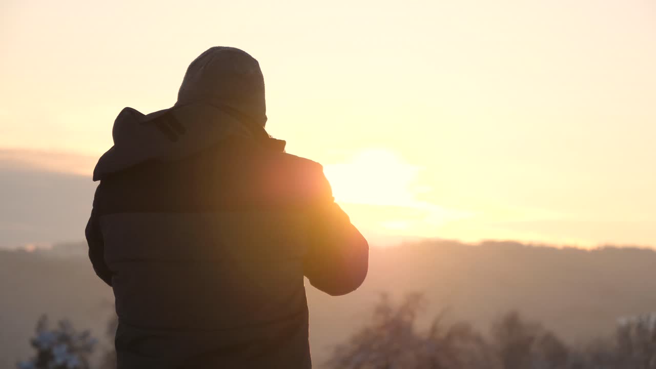 Man Silhouetted Against a Winter Sunrise