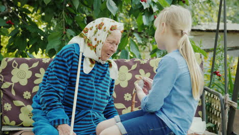 the girl shows her handmade work to her grandmother communion of generations concept