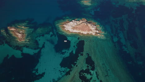 aerial view of turquoise ocean with rocky islands and a boat