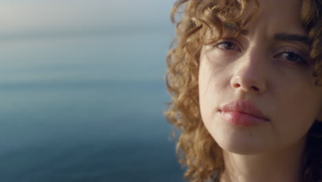 Upset-woman-posing-on-camera-at-sea.-Cheerful-girl-with-serious-face-expression