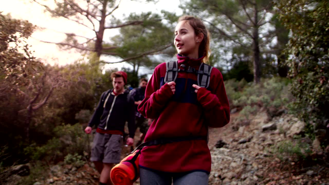 Group of friends with backpacks hiking in a forest