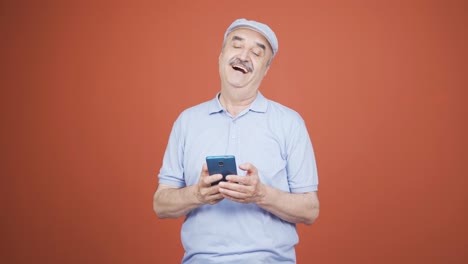 The-old-man-looking-at-the-phone-is-happy.