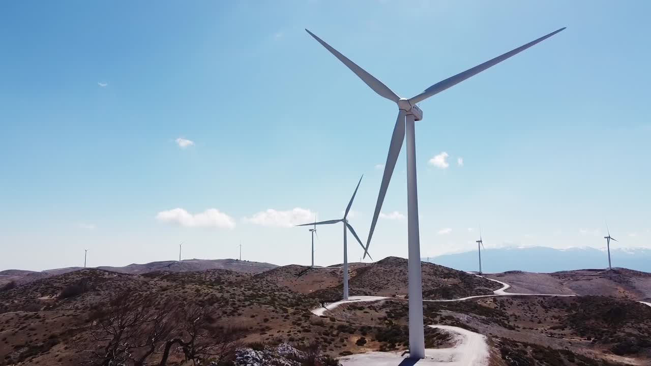 Parco eolico aereo in montagna greca vicino alla città di Veria durante una splendida giornata di sole con cielo azzurro, Grecia.