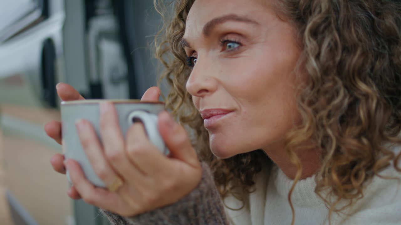 retrato de turista que sostiene una taza con bebida caliente sentado en las escaleras de la caravana