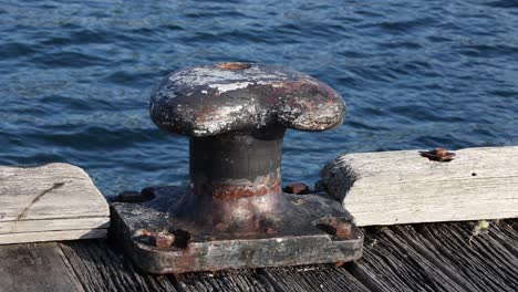 rusty bollard on pier by the water