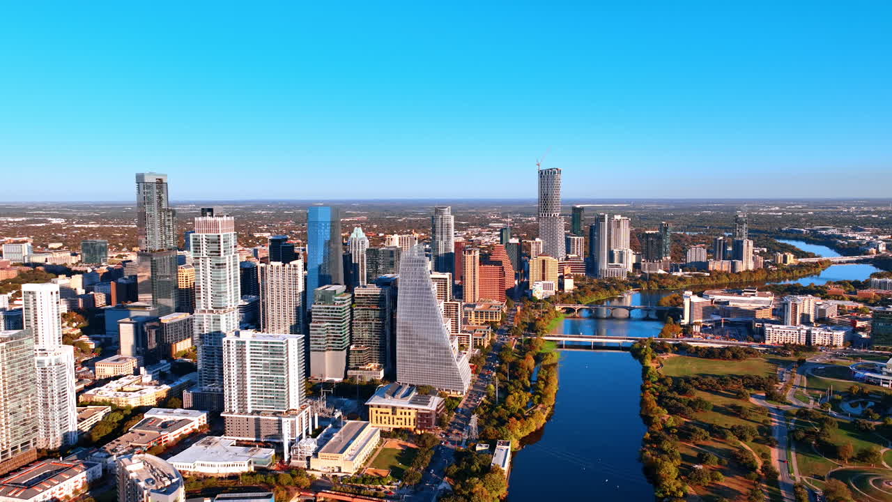 Rauhallinen, aaltoileva Colorado-joki virtaa Austinin, Texasin, USA:n kaupunkimaiseman ohi. Näkymä korkeiden rakennusten keskustaan, joka sijaitsee veden äärellä. Ilmaperspektiivi.