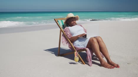 senior woman using laptop at the beach