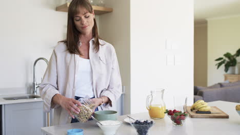 mujer caucásica de mediana edad prepara el desayuno en una cocina de casa