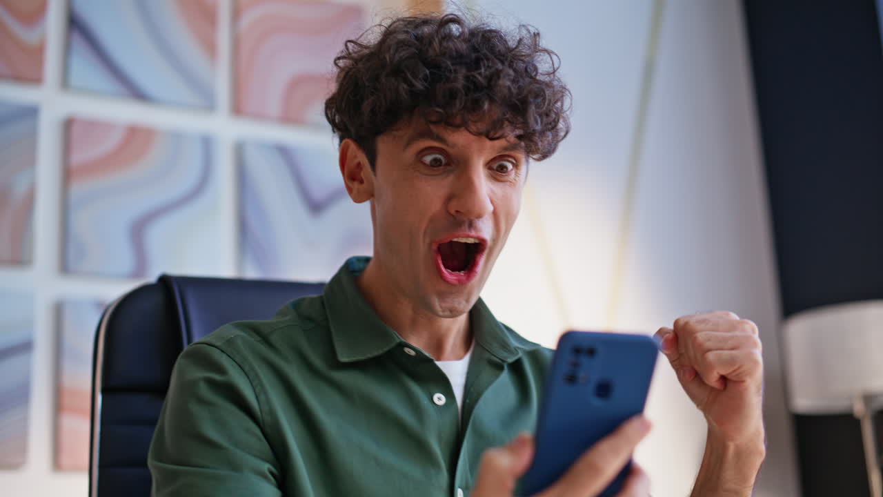 Man celebrating success while using phone